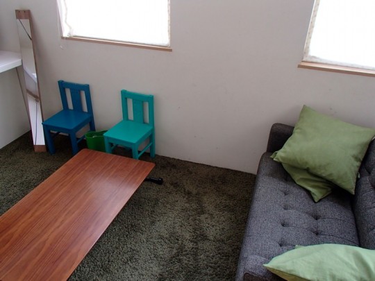 グリーンの椅子とゴミ箱とカーペットとソファとクッション
